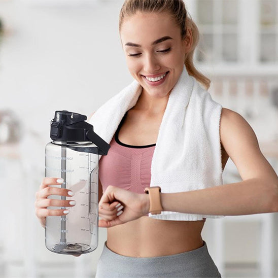 gourde sport dans main droite femme regarde heure montre