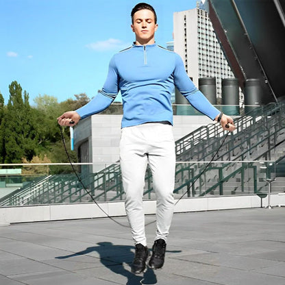 corde-a-sauter-cardio-homme-en-exterieur-pull-bleu-jogging-blanc
