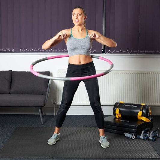 femme fait hula hoop devant canapé sur tapis gym