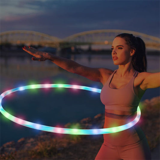 femme hula hoop lumineux autour taille sable plage