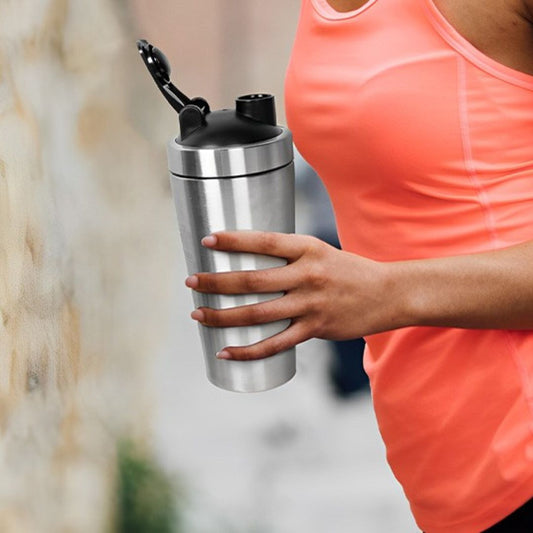 femme sportive avec shaker gris dans main gauche