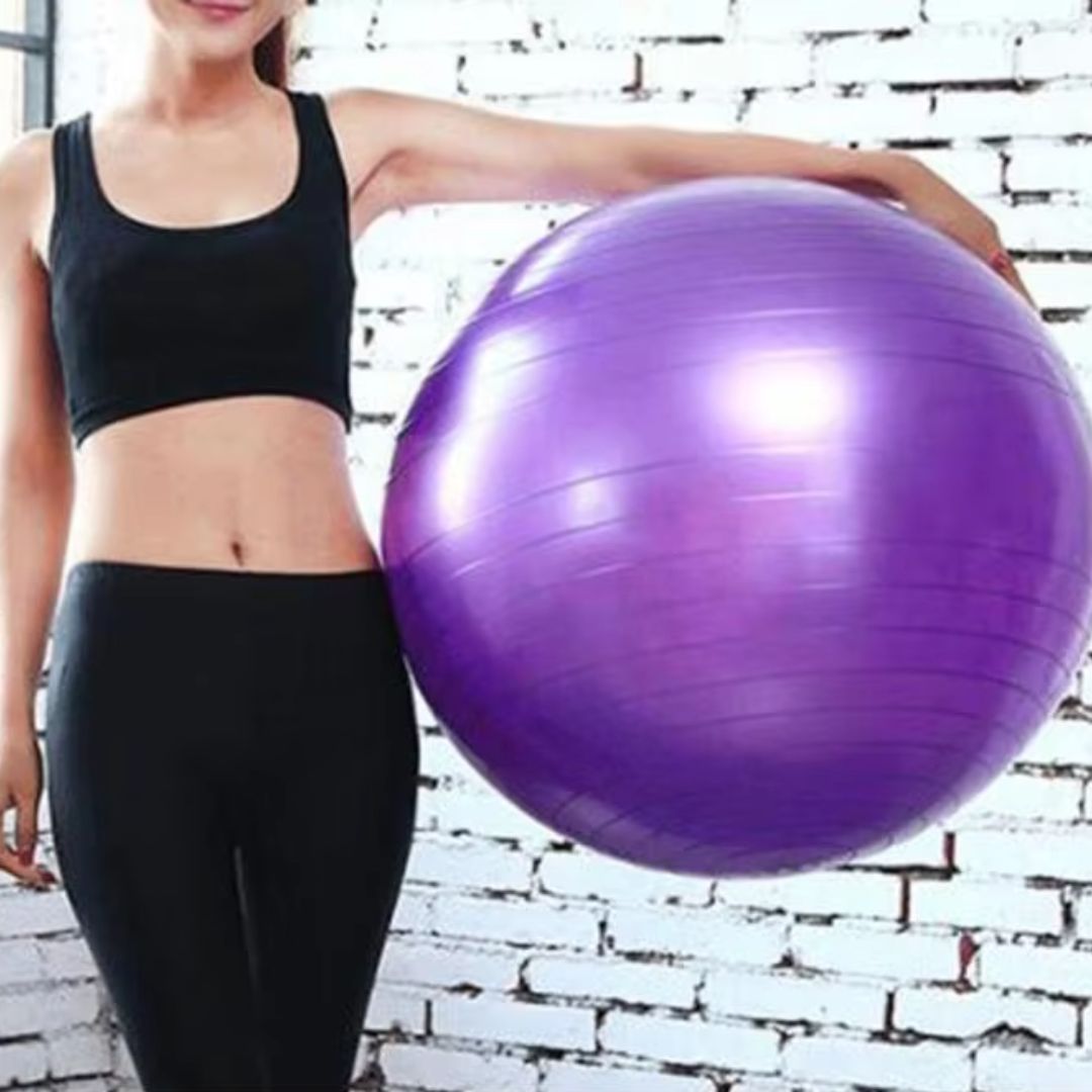 femme tient swiss ball violet sous bras gauche tendu
