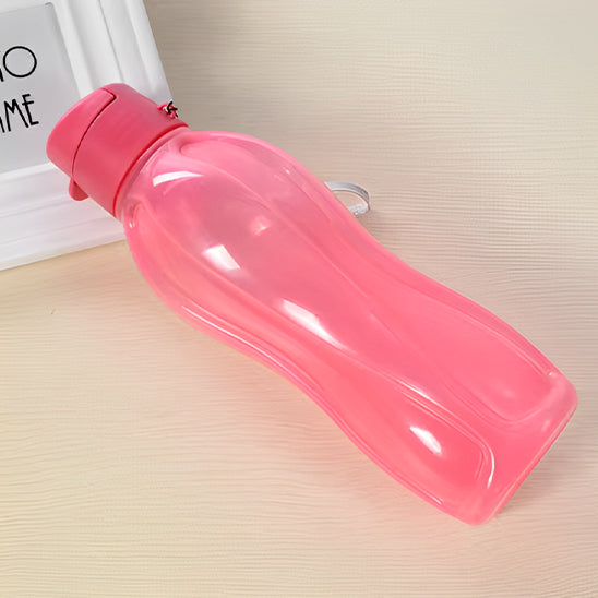 gourde plastique rose transparente couchee sur table