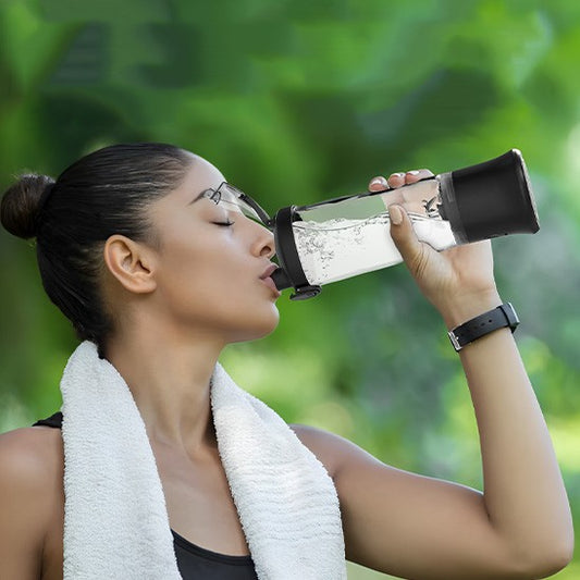 shaker dans main gauche femme qui boit serviette sur les épaules