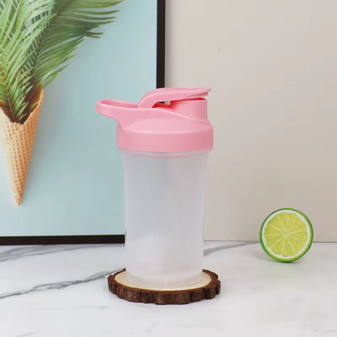 shaker protéine rose en présentation à côté rondelle citron vert et plante